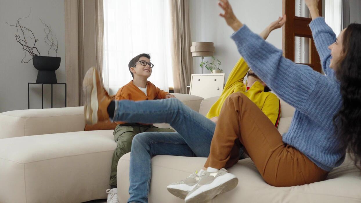 family having fun and playing with a red balloon in their cozy living room video